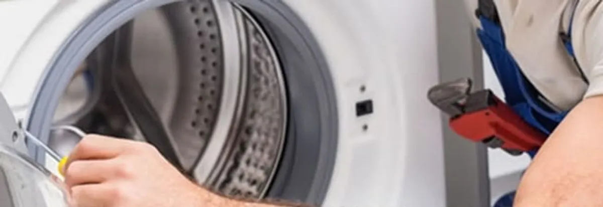Appliance technician repairing a clothes dryer drum and internal parts in Tacoma, WA