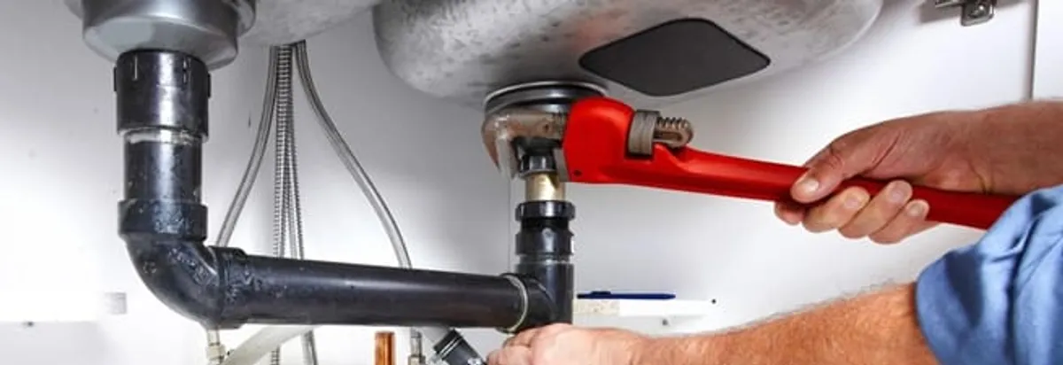 Garbage disposal repair technician tightening the sink drain and disposal connection in Tacoma, WA