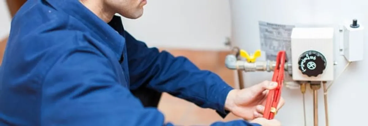 Water heater repair technician adjusting the temperature control and gas valve in Tacoma, WA